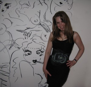 Stacy in front of wall of sketches by Jimmy Cummins!